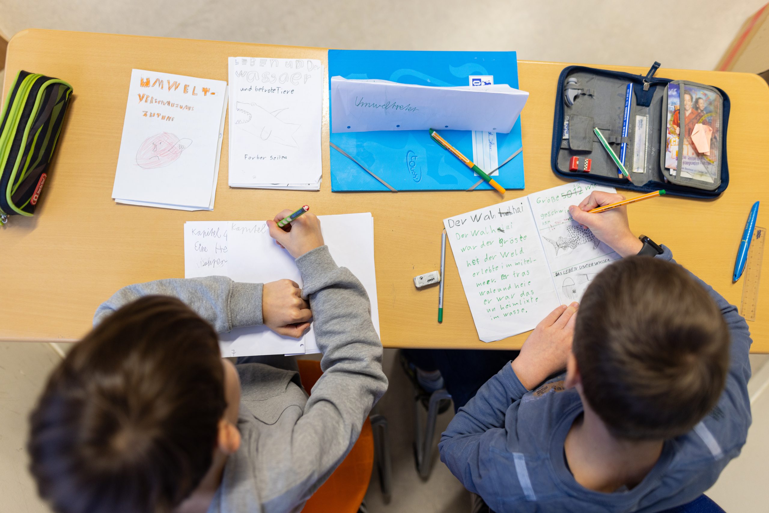 Zwei Schüler schreiben über politische Themen.