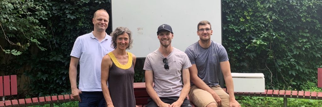 Die Betreuenden und Studierenden des Studiengangs Schulassistenz in Qualifizierung sitzen im so genannten Grünen Klassenzimmer im Freien. Von links nach rechts sind zu sehen: Die Betreuenden Dirk Wohlrabe und Nadine Matthes von der TU Dresden sowie die Studierenden Jonathan Markus und Felix Fuchs.